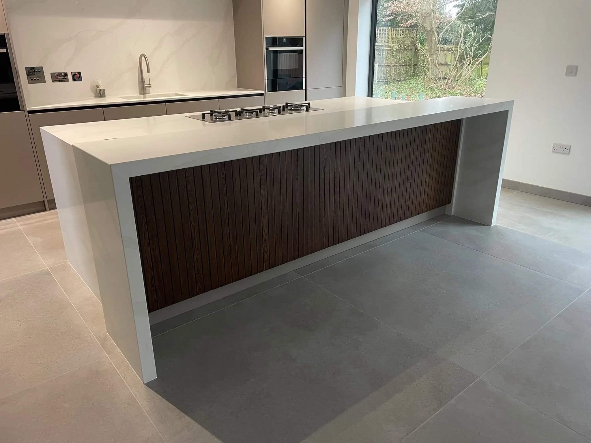 Calacatta Supreme Quartz: waterfall island with a timber slatted front