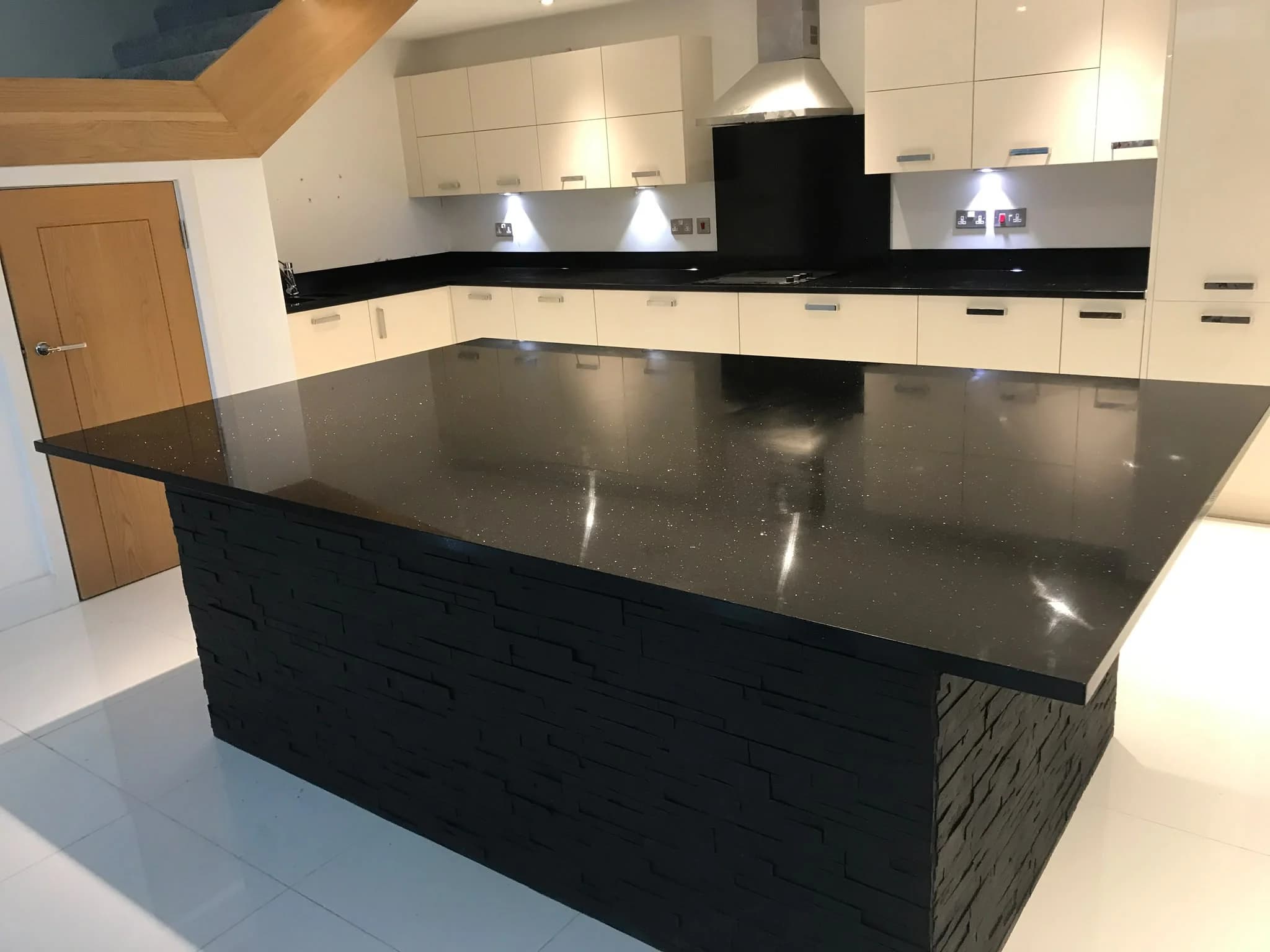 Star Galaxy Granite island with a dark stone-clad base.