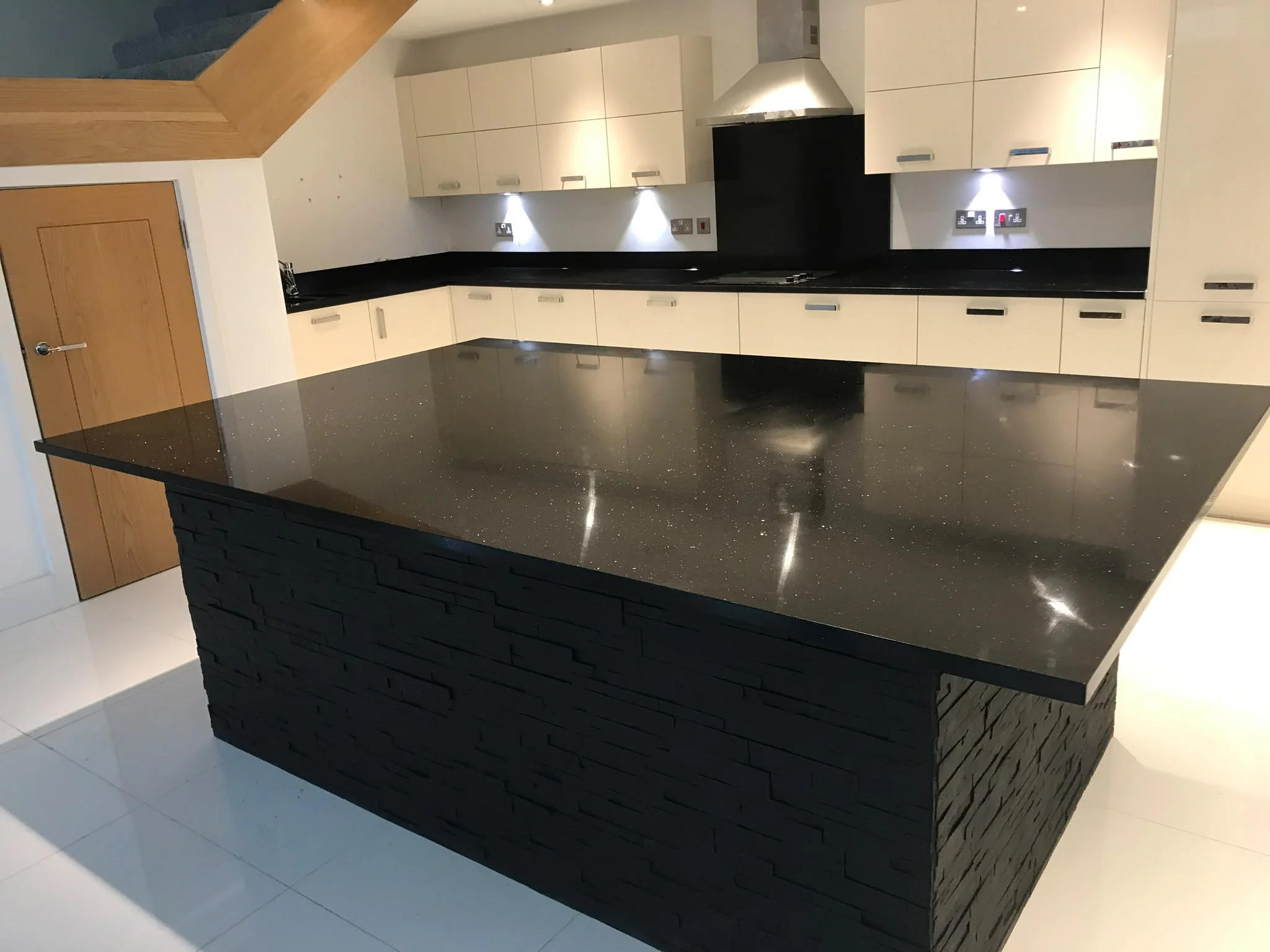 Star Galaxy Granite island with a dark stone-clad base.