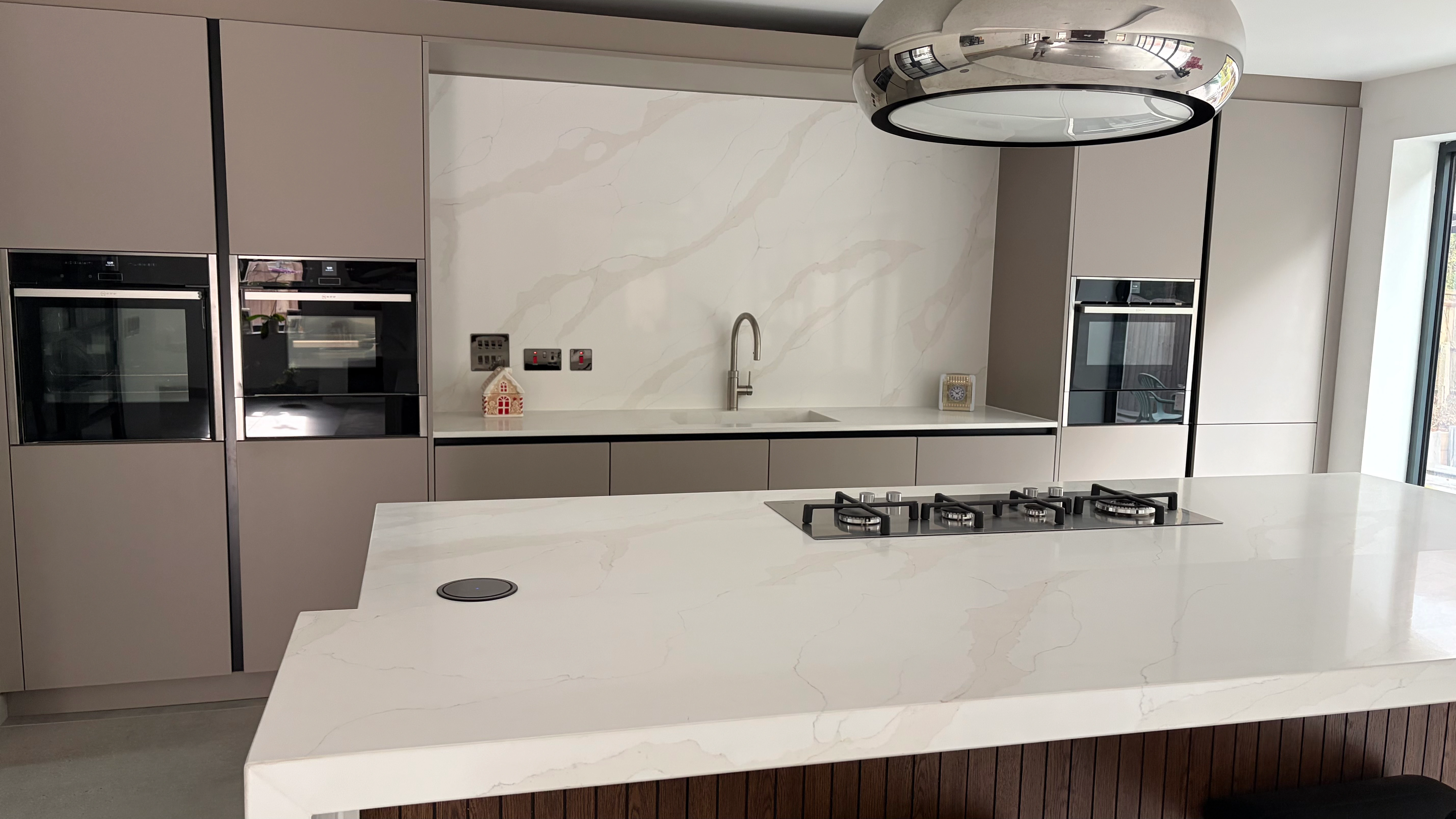 Calacatta Supreme Quartz worktop island and full-height splashback in a fitted kitchen
